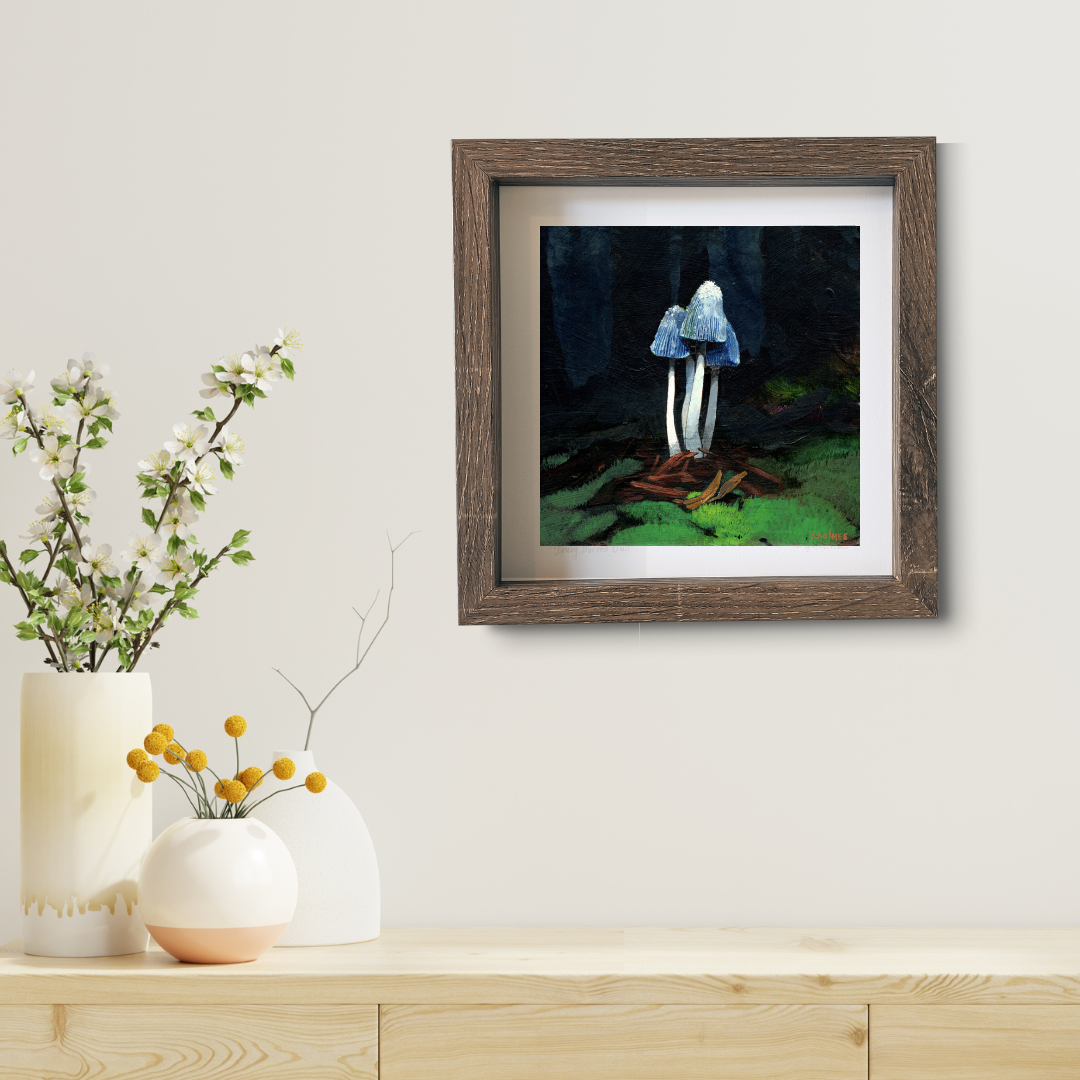 An art print of a young shaggy mane mushroom in a brown frame in a modern living room.