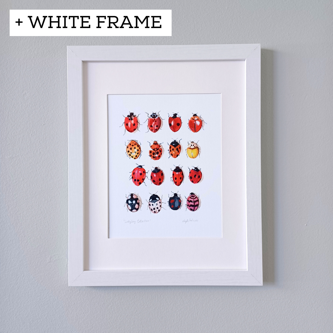 A photo of the ladybug art print framed and hanging on a gray wall.