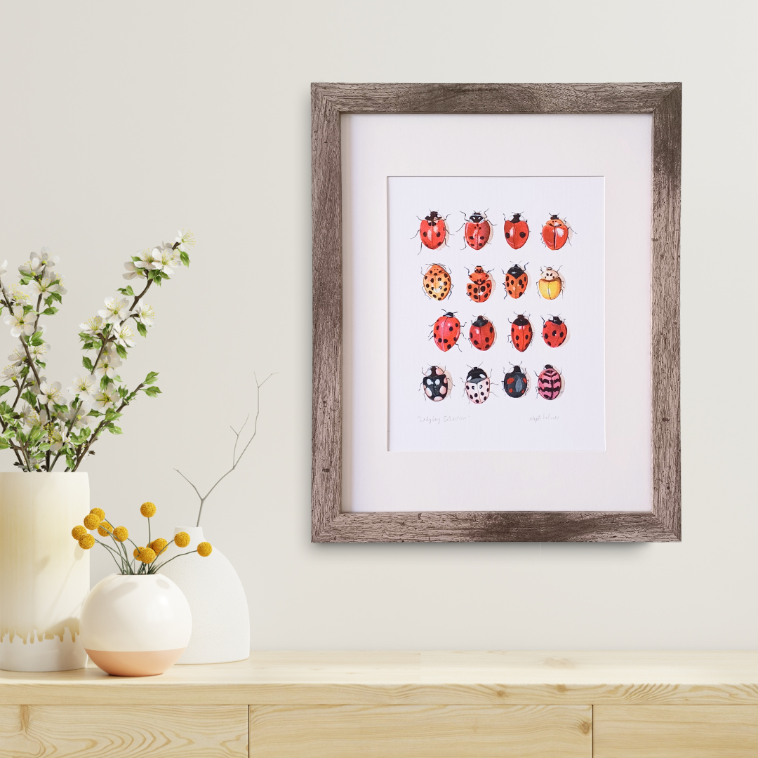 A ladybug collection art print on the wall with a few vases and flowers next to it.